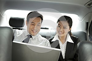 Business people working with laptop in the car