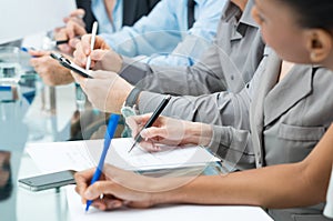 Business People Writing Notes In Meeting