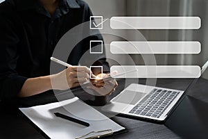 Business performance checklist concept, businessman using tablet and laptop doing online checklist survey, filling out digital