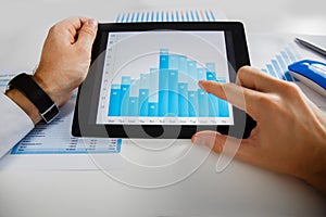 Business person analyzing financial statistics displayed on the tablet screen