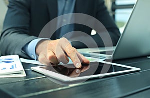 Business person analyzing financial statistics displayed on the tablet screen.