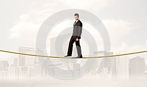 Business person balancing on golden rope