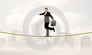 Business person balancing on golden rope