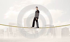 Business person balancing on golden rope