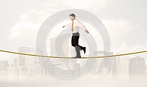 Business person balancing on golden rope