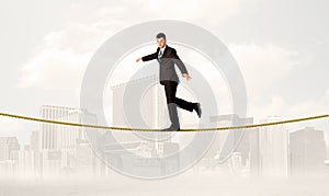 Business person balancing on golden rope