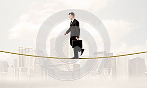 Business person balancing on golden rope