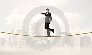 Business person balancing on golden rope