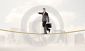 Business person balancing on golden rope