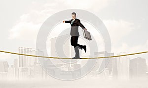 Business person balancing on golden rope