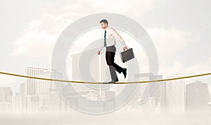 Business person balancing on golden rope
