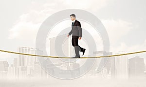 Business person balancing on golden rope