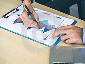 Business person checking report chart on desk in office