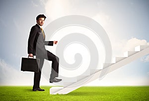 Business person climbing up on white staircase in nature