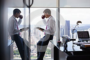 Business Person With Coffe Cup Reading News On Tablet