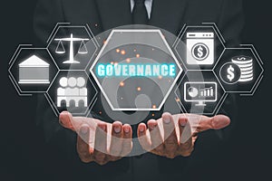 Business person hand holding governance icon on virtual screen