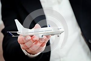 Business person holding airplane model. Transport, aircraft industry, airline