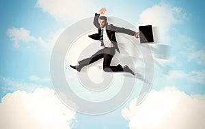 Business person jumping over clouds in the sky