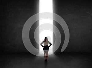 Business person looking at wall with light tunnel opening