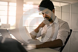 Business person in office. African business man reading document