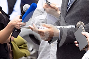 Business person or politician talking with journalists and reporters at news conference