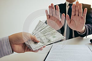 Business person refusing bribe given money by partner with anti bribery corruption concept