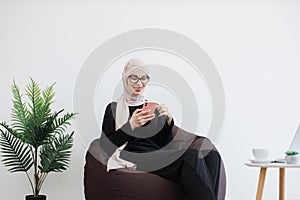 Business person replying to email via phone in workspace