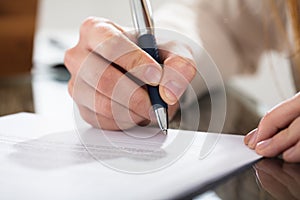 Business Person Signing Document With Pen