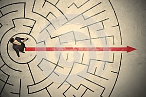 Business person standing in the middle of a circular maze