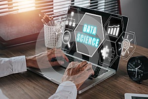 Business person using laptop on desk with Data science icon on virtual screen