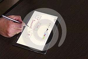 Business person working on wooden table Indoors, using tablet and stylos. Business