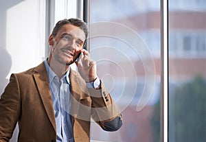 Business, phone call and man at window in office networking, deal negotiation or conversation. Communication