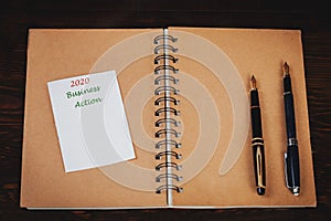 Business plan on book note with vintage compass and fountain pen over table