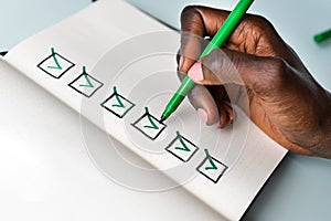 Business Plan Checklist. Hand Ticking Checkboxes