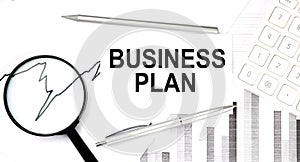 Business plan document with pen,graph and magnifier,calculator