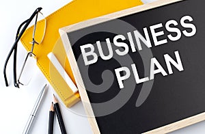 Business Plan text on blackboard with notepad ,pe,pencil