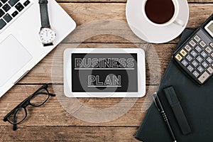 Business Plan text on tablet computer, Office desk with computer