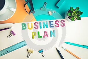 Business plan word on desk office background with supplies.