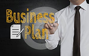 Business plan is written by businessman on screen