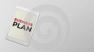 Business plan written on the screen of computer tablet