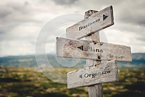 Business, plans and organize wooden signpost outdoors in nature.