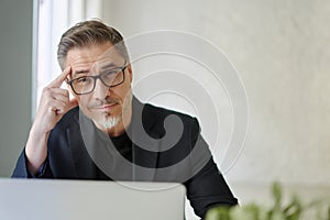 Business portrait - Businessman sitting at desk in office.