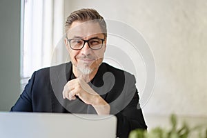 Business portrait - Businessman sitting at desk in office.