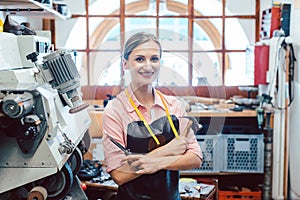 Business portrait of owner in her small cobbler workshop