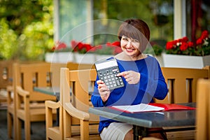 Business portrait of a woman who works as an accountant, economist with documents and a calculator