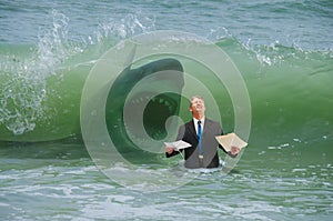 Business pressure man getting hit by wave with attacking shark