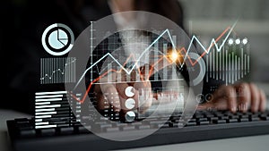 Business professional analyzing data trends on digital screen with financial graphs and charts overlay in modern office