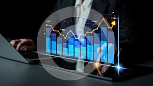 Business Professional Analyzing Financial Data with Digital Graphs on Laptop in Office Environment at Night with