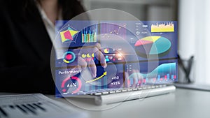 Business professional interacting with digital data visualization interface displaying graphs, charts, and performance