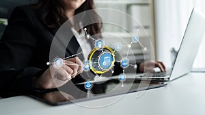 Business professional interacting with virtual technology interface while working on a laptop in a modern office